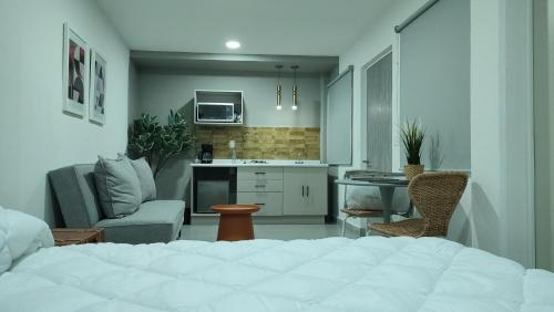 1 dormitorio con 1 cama blanca y cocina en WUER Expiatorio en León