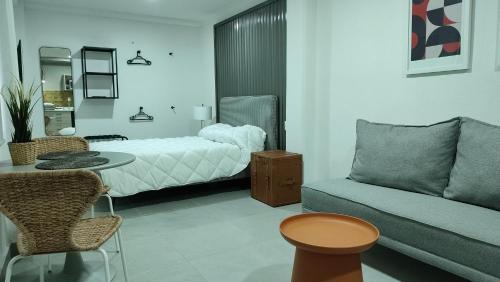 a bedroom with a bed and a couch and a table at WUER Expiatorio in León