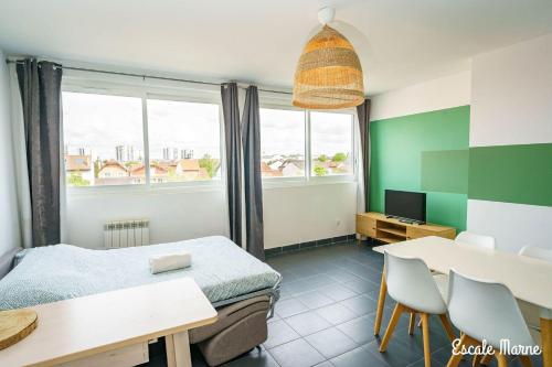 een slaapkamer met een bed, een tafel en een bureau bij escale-marne fr - 21 - Appartement entier, 4 pers, 10mn metro 8, RER A, Parking rue Gratuit, Grand Matelas Emma, Cuisine Équipée, Vue panoramique, 2ème étage in Maisons-Alfort