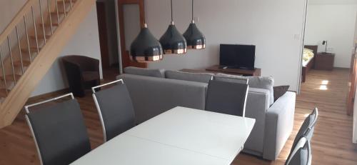 a living room with a couch and a table and chairs at Villa Appartements in Františkovy Lázně