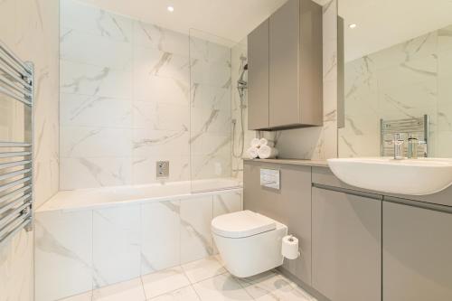 a white bathroom with a sink and a toilet at The Cornerstone Two by Dublin At Home in Dublin