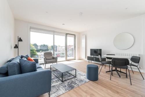 a living room with a blue couch and a table at The Cornerstone Two by Dublin At Home in Dublin