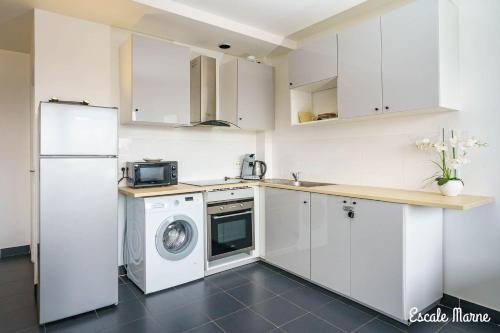 une cuisine avec un lave-linge et un réfrigérateur dans l'établissement Escale-marne fr - 101 - Free Parking - Free Luggage Storage - All equipped - Linen Included - Washing Machine - Luxury Eve Sleep Mattress 160X200 - 10mn Walk Métro 8 - RER A - Panoramic View - From 1 to 4 guests, à Maisons-Alfort