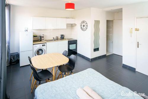 a kitchen with a table and some chairs and a table at Escale-marne fr - 102 - Free Parking - Free Luggage Storage - Metro 8 Eiffel Tower - All equipped - Linen Included - Washing Machine - Panoramic View - From 1 to 4 guests in Maisons-Alfort