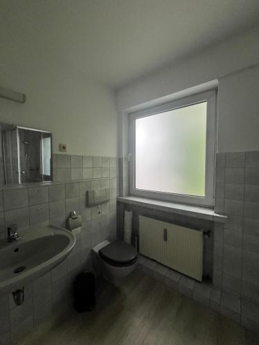 a bathroom with a toilet and a sink and a window at Wohnung für Monteure (Einzelzimmer / Doppelzimmer) in der Nähe von Köln/Bonn/Hennef/Waldbröl in Waldbröl