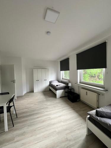 una grande camera bianca con un letto e un tavolo di Wohnung für Monteure (Einzelzimmer / Doppelzimmer) in der Nähe von Köln/Bonn/Hennef/Waldbröl a Waldbröl