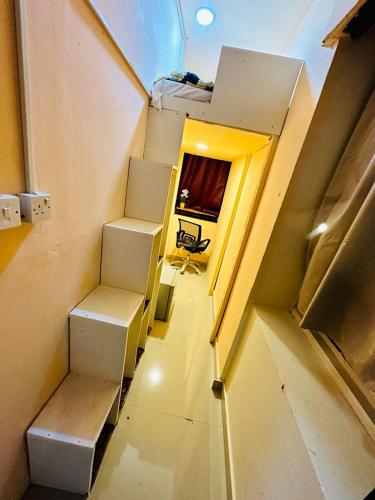 Couples Loft Partition CLOSE to MALL OF EMIRATES METRO في دبي: غرفة صغيرة مع درج مع غرفة مع طاولة