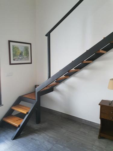 a black staircase in a white room with a desk at Casa da Praça in Ponte de Sor
