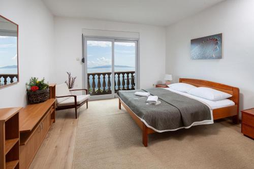 a bedroom with a large bed and a balcony at Apartments Green Garden in Opatija