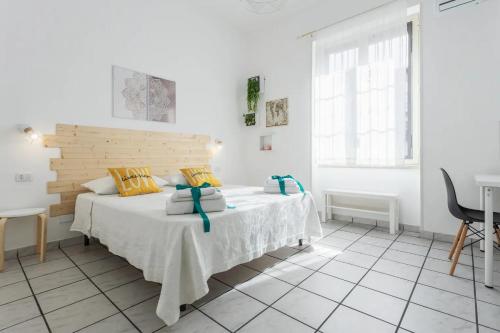 1 dormitorio blanco con 1 cama con cabecero de madera en Sophi's house, en Palermo