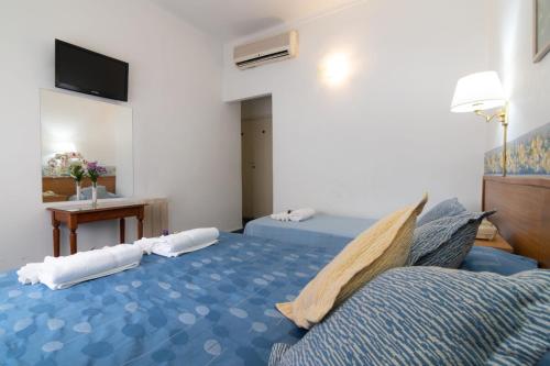 a room with two beds and a table and a television at Apolo Atlantis in Mar del Plata