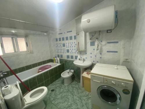 ein Bad mit einem WC, einem Waschbecken und einer Waschmaschine in der Unterkunft Aparttamento in Tirana