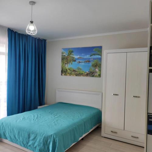 a bedroom with a green bed and blue curtains at Townhouse 4/11 in Bosteri