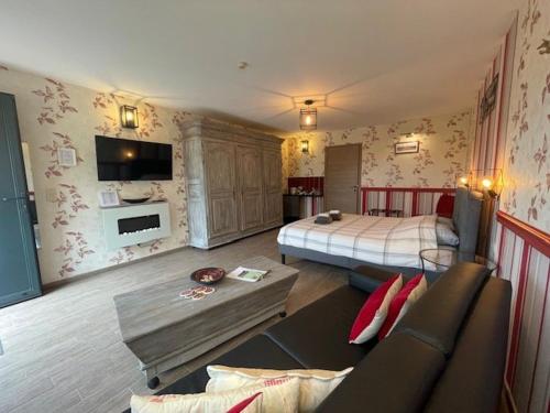 1 dormitorio con 1 cama y 1 sofá en una habitación en B&B Le Bouchat-Oreille, en Spontin