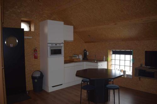 una cucina con tavolo e frigorifero bianco di Lî Stôle a Durbuy