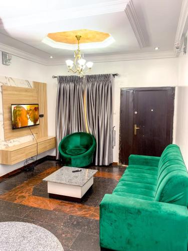 ein Wohnzimmer mit einem grünen Sofa und einem Tisch in der Unterkunft 24B Maye Ogunda in Lagos