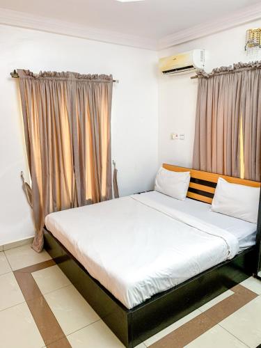 a large bed in a room with curtains at 24B Maye Ogunda in Lagos