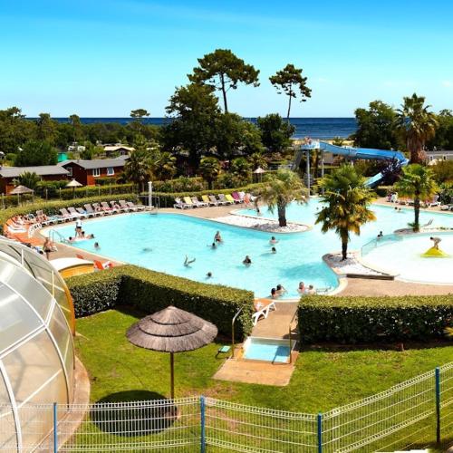 un groupe de personnes dans une piscine d'un complexe hôtelier dans l'établissement Camping 4 etoiles les viviers lege cap ferret, à Lège-Cap-Ferret