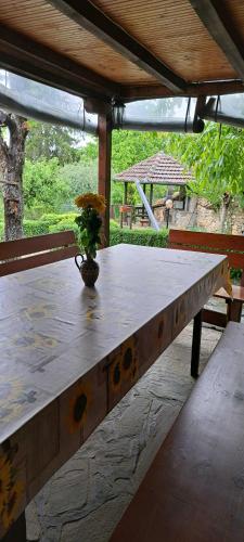 una mesa de madera en un porche con un jarrón. en Дядо Цоньовата къща en Sevlievo