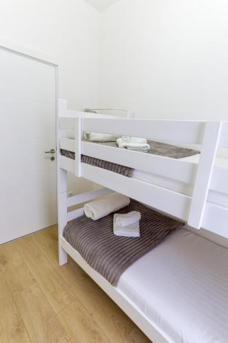 a white bunk bed in a room with a wooden floor at Airport Belgrade Apartments in Surčin