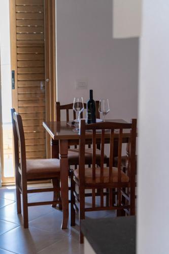 a dining room with a table and chairs with wine glasses at Vila Anxhelo in Vlorë