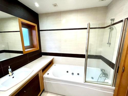 a bathroom with a tub and a sink and a shower at A Casa do Pai Carlos in Salreu