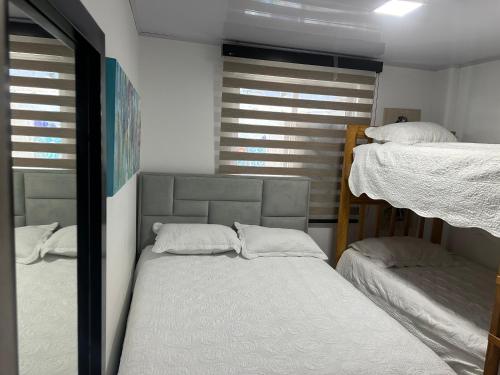 a bedroom with two bunk beds and a mirror at ATLANTIS CASA BOUTIQUE , con jacuzzi cerca de la playa in San Andrés