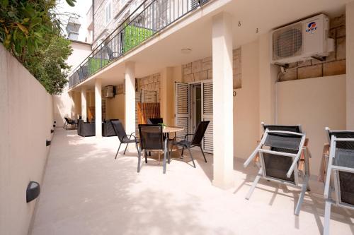 a patio with chairs and a table in a building at Villa Rajski Dvor in Bol