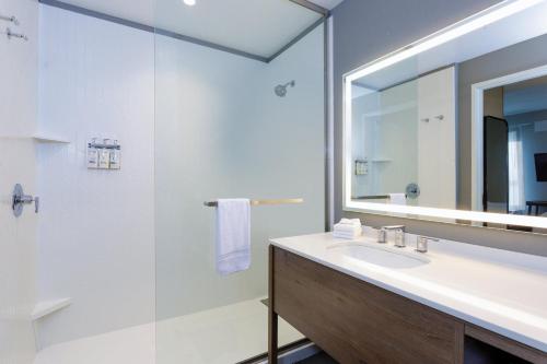 a bathroom with a sink and a shower and a mirror at Staybridge Suites Winter Haven - Auburndale in Winter Haven