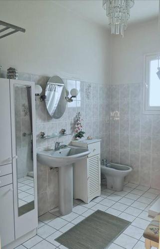 une salle de bain avec un lavabo, des toilettes et un miroir dans l'établissement Chez Nadine, à Roquecor
