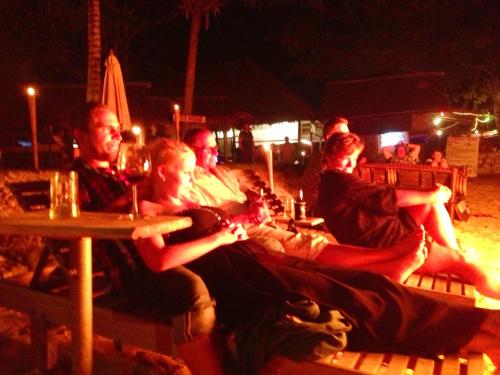 a group of people sitting at a table at night at Nautilus Right on the Beach - Adult Only - SHA Extra Plus in Ko Lanta