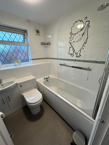 a bathroom with a toilet and a tub and a sink at Hinckley Home Leysmill in Hinckley