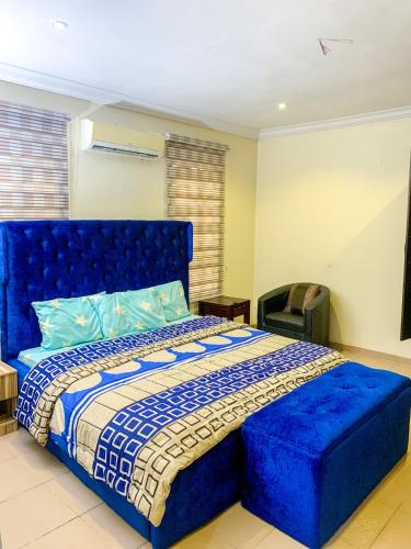 a bedroom with a blue bed with a blue tufted headboard at 28B (3/2B) in Lagos
