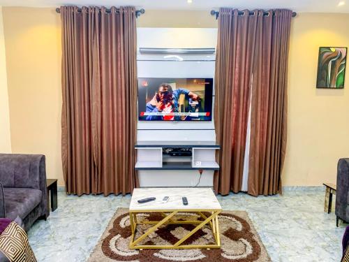 a living room with a tv and a couch at 28B (3/2B) in Lagos