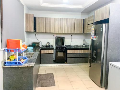 eine Küche mit schwarzen Arbeitsplatten und einem Kühlschrank in der Unterkunft 28B (3/2B) in Lagos