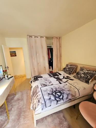 een slaapkamer met een bed met een bloem erop bij Appartement proche de l'aéroport CDG & stade de France in Aulnay-sous-Bois