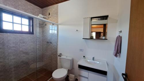 y baño con aseo, lavabo y ducha. en Casa Sossego na Montanha, en Campos do Jordão
