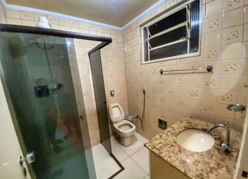 a bathroom with a toilet and a sink and a shower at Casarão Hostel in Guaratinguetá
