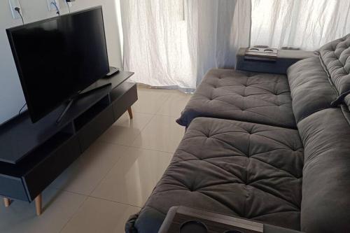 un soggiorno con divano e TV a schermo piatto di Casa aconchegante Gran Ville a Rondonópolis