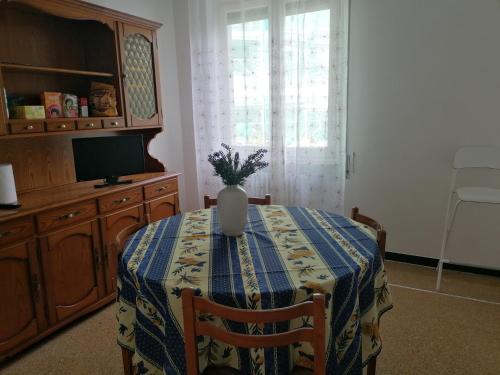 une table à manger avec un vase au-dessus dans l'établissement La casa di Rossella - Genova, Quarto mare, à Gênes