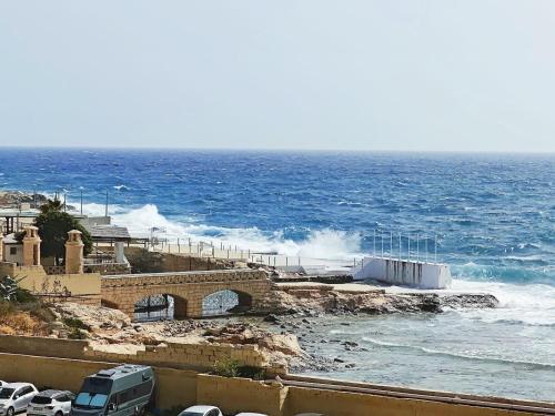 a view of the ocean with waves crashing on the shore at Seabreeze Serenity Dragonara Horizon Residence in Paceville