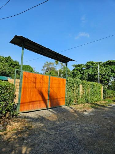 a fence with an orange gate with a shadow at Betulio's Oasis in Fortuna