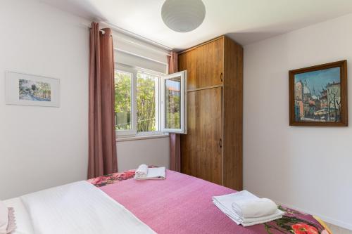 a bedroom with a bed with a pink blanket at Stephanie green island apartments in Šipanska Luka