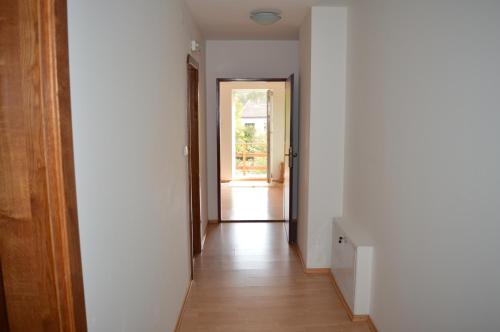 a hallway with white walls and a wooden floor at Davi Penzion & Bowling in Rožňava