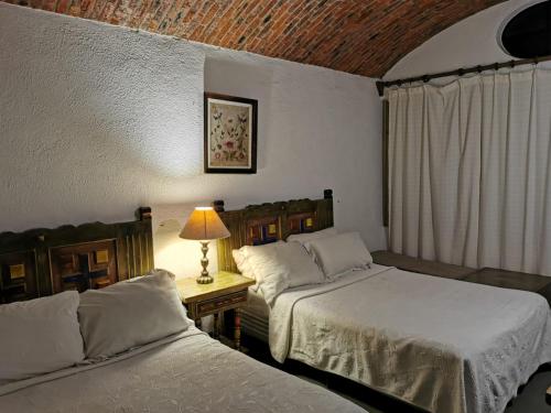 1 dormitorio con 2 camas y mesa con lámpara en Suite linda vista, en San Miguel de Allende