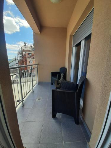 a balcony with chairs and a view of a building at Lux Apartman Jovana in Žabljak