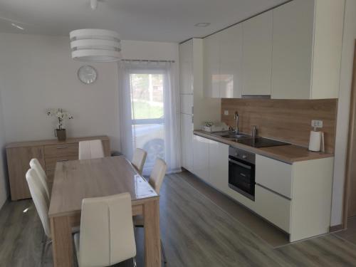 Grude的住宿－Žuta kuća，一间带桌子的厨房和一间带白色橱柜的厨房