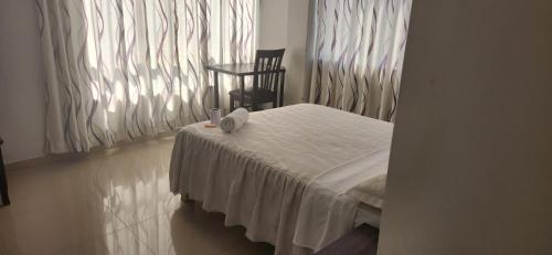 Habitación con cama, silla y ventana en Hotel Gran Marquez en Moquegua