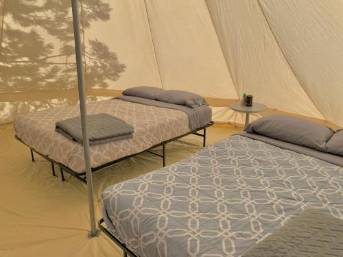 two beds in a tent with a table at Zion View Camping in Hildale