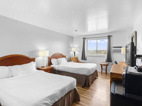 una camera d'albergo con due letti e una televisione di Value Stay Lodge ad Alliance